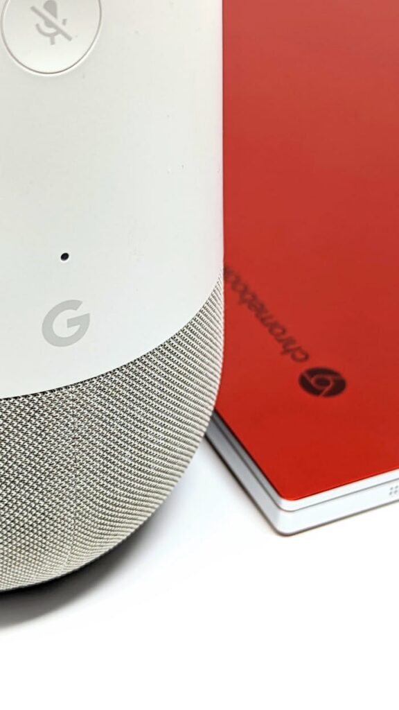 A smart home speaker next to a red notebook, showcasing modern tech accessories.